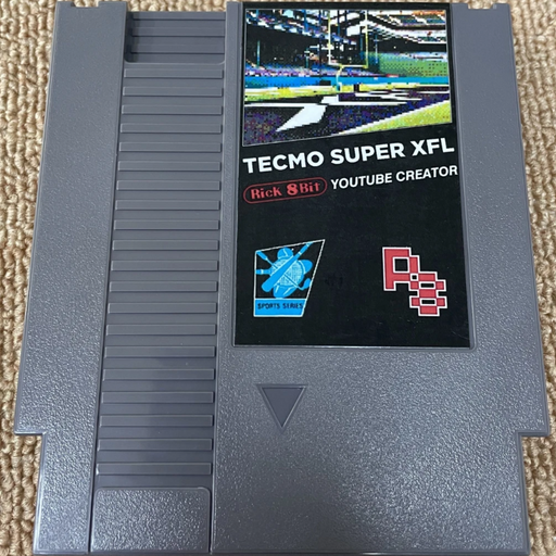 Tecmo Super XFL game cartridge on a beige carpet