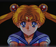 Animated character with blonde hair and blue eyes, wearing a sailor uniform, on a dark background.