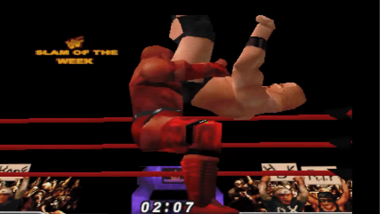 A low-resolution screenshot from a wrestling video game showing a wrestler in a red outfit executing a move on an opponent inside a ring, with on-screen text including 'SLAM OF THE WEEK' and a timer.