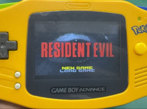 Yellow Game Boy Advance with 'Resident Evil' on screen held by a hand
